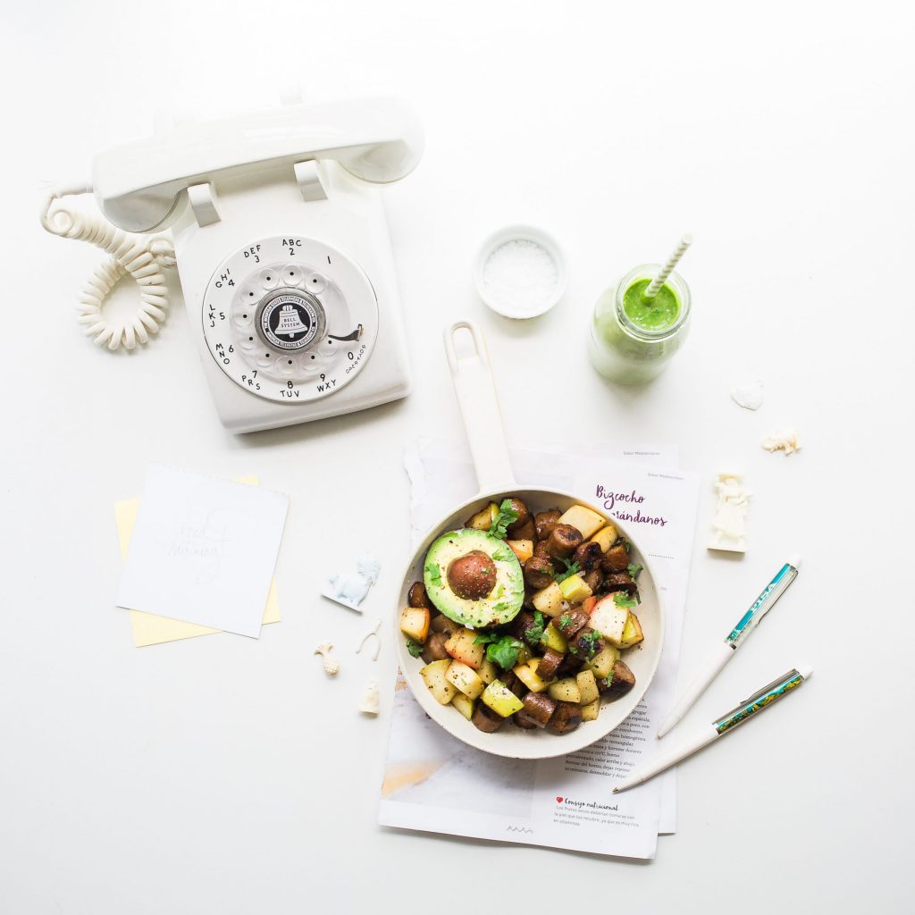 sliced avocado fruit inside bowl near rotary phone beside jar